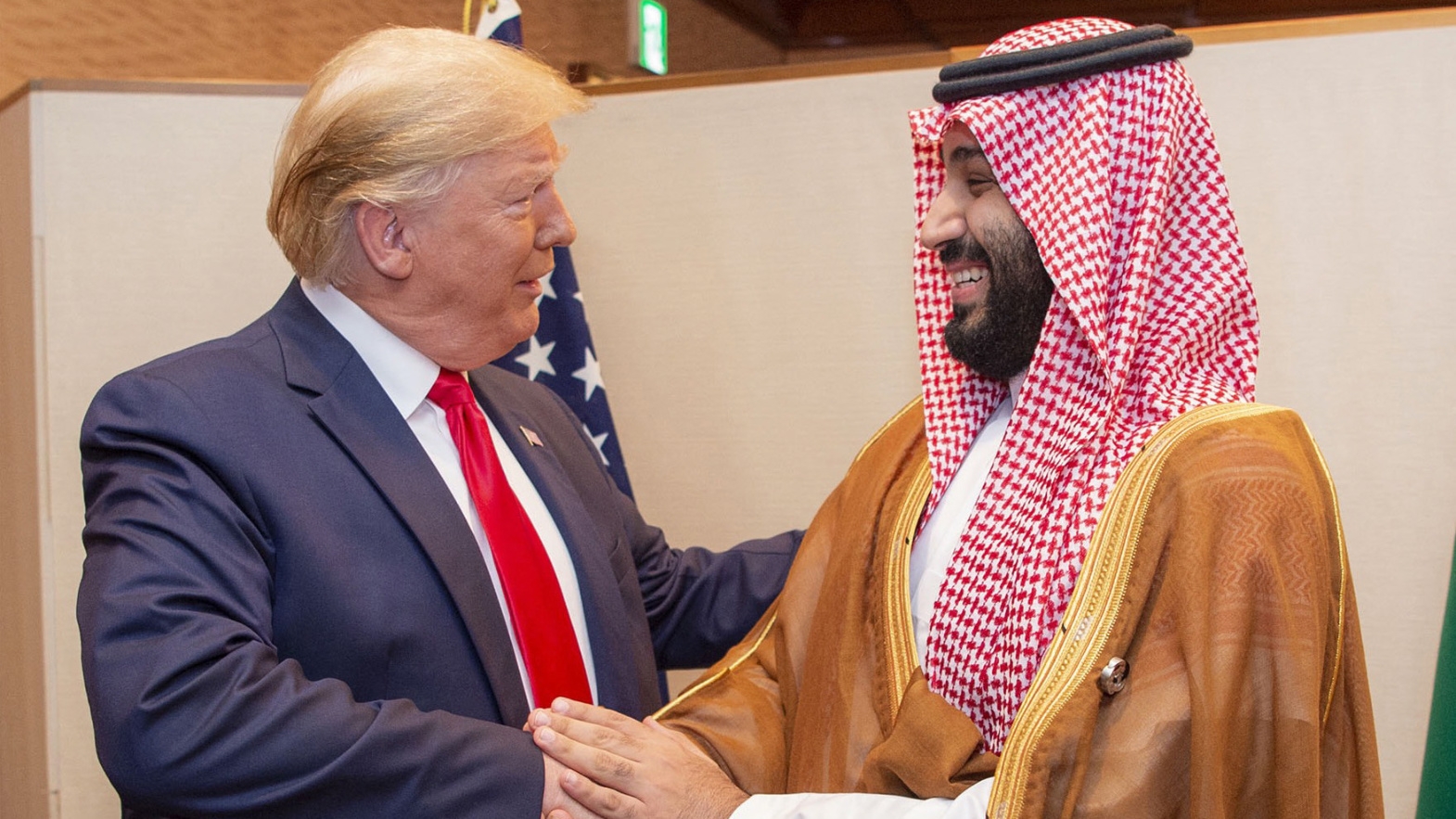 A handout picture provided by the Saudi Royal Palace on 29 June 2019 shows Saudi Crown Prince Mohammed bin Salman shaking hands with then-US President Donald Trump in Osaka, Japan (Bandar al-Joud/Saudi Royal Palace/AFP)