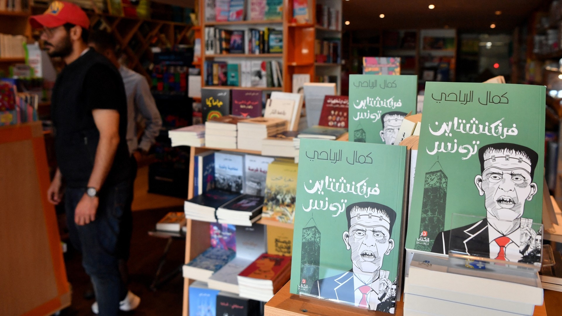 People visit the Dar El-Kitab book shop in Tunis on 29 April 2023, where a book titled "The Tunisian Frankenstein" is displayed (AFP)