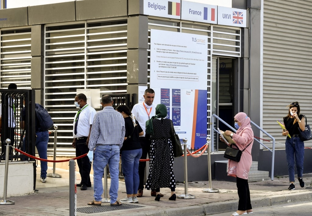 Des Tunisiens font la queue devant les bureaux de TLScontact, une société qui travaille avec les gouvernements du monde entier pour fournir des services de visa, à Tunis, le 29 septembre 2021 (AFP/Fethi Belaïd)