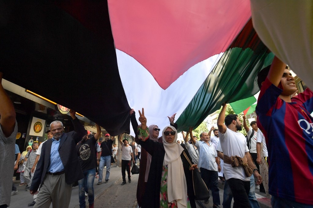 Des Tunisiens manifestent sous un immense drapeau de la Palestine, le 13 octobre à Tunis (AFP/Fethi Belaid)