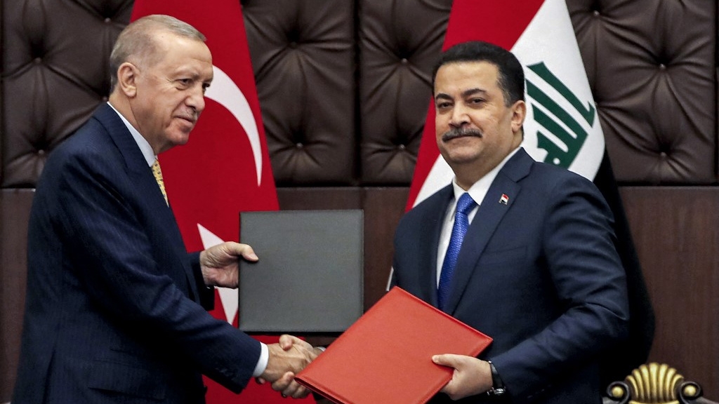 Iraqi Prime Minister Mohammed Shia al-Sudani (R) and Turkish President Recep Tayyip Erdogan exchange signed agreements in Baghdad on 22 April 2024 (Ahmad al-Rubaye/Pool/AFP)