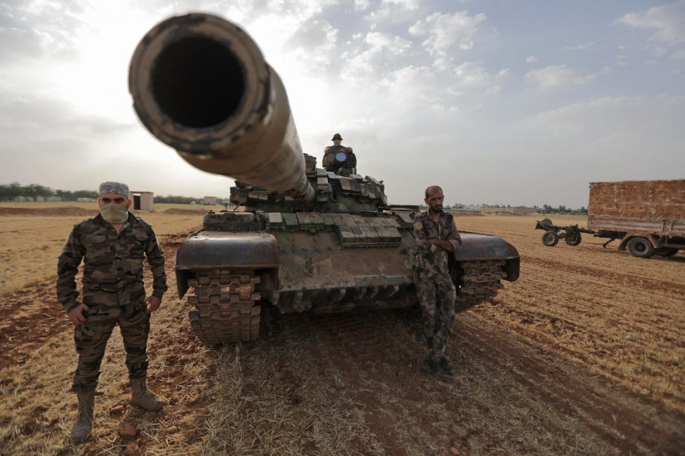  Des combattants syriens, soutenus par la Turquie, autour d’un char lors d’un exercice militaire dans la campagne de Manbij, en Syrie, le 2 juin 2022 (AFP)