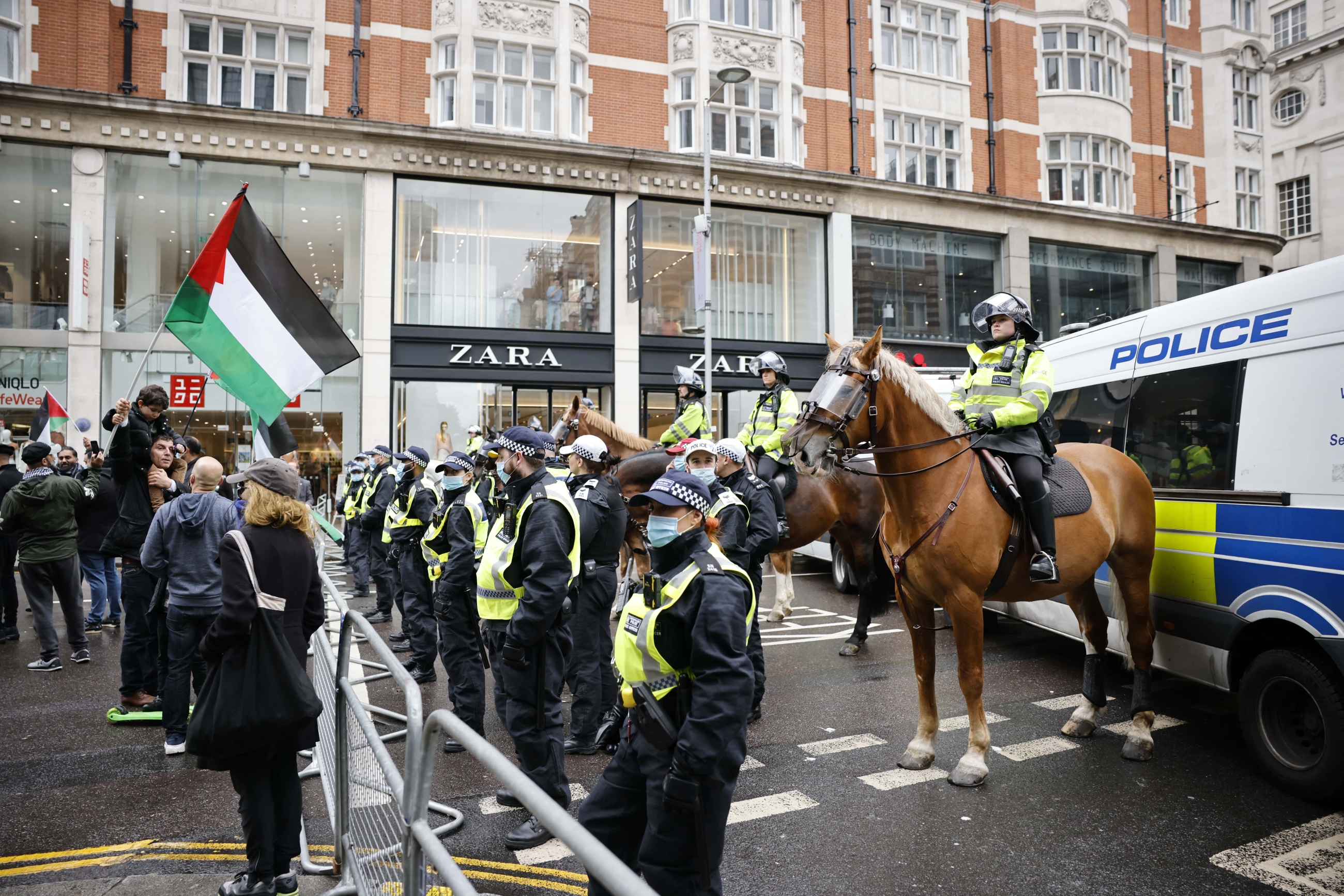 Protester with a Palestinian flag at a police cordon during a protest in central London on 23 May 2021 (AFP/File photo)