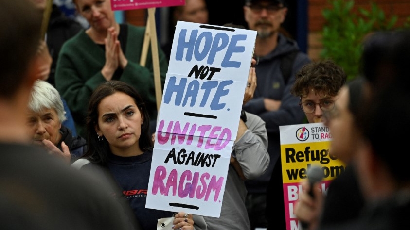 Protesters hold placards during a counter-demonstration against far-right activists in Oxford, western England, on 7 August 2024 (Justin Tallis/AFP)