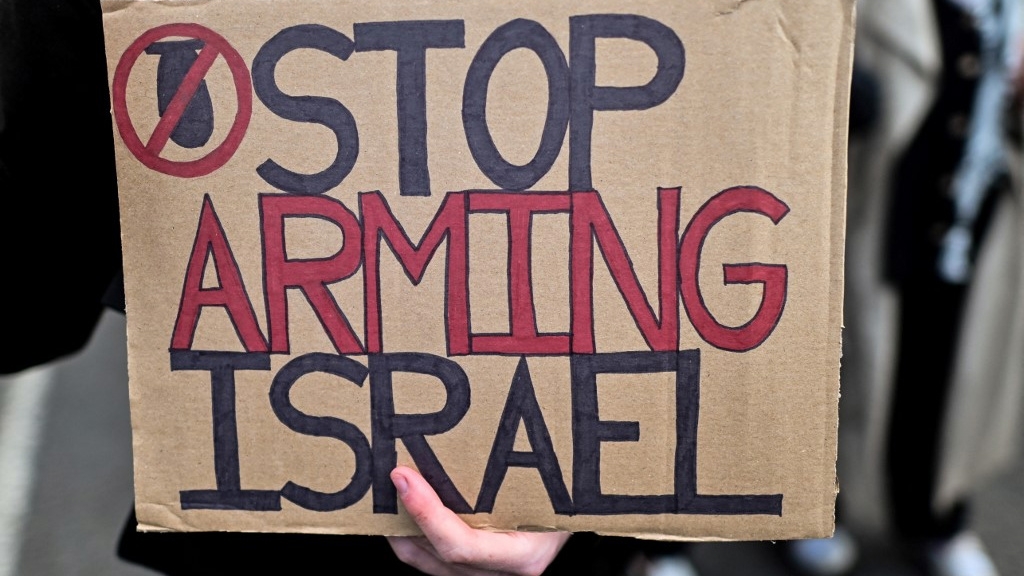 A pro-Palestinian protester holds a placard outside the Palace of Westminster in central London on 17 April 2024 to denounce British arms exports to Israel (Justin Tallis/AFP)