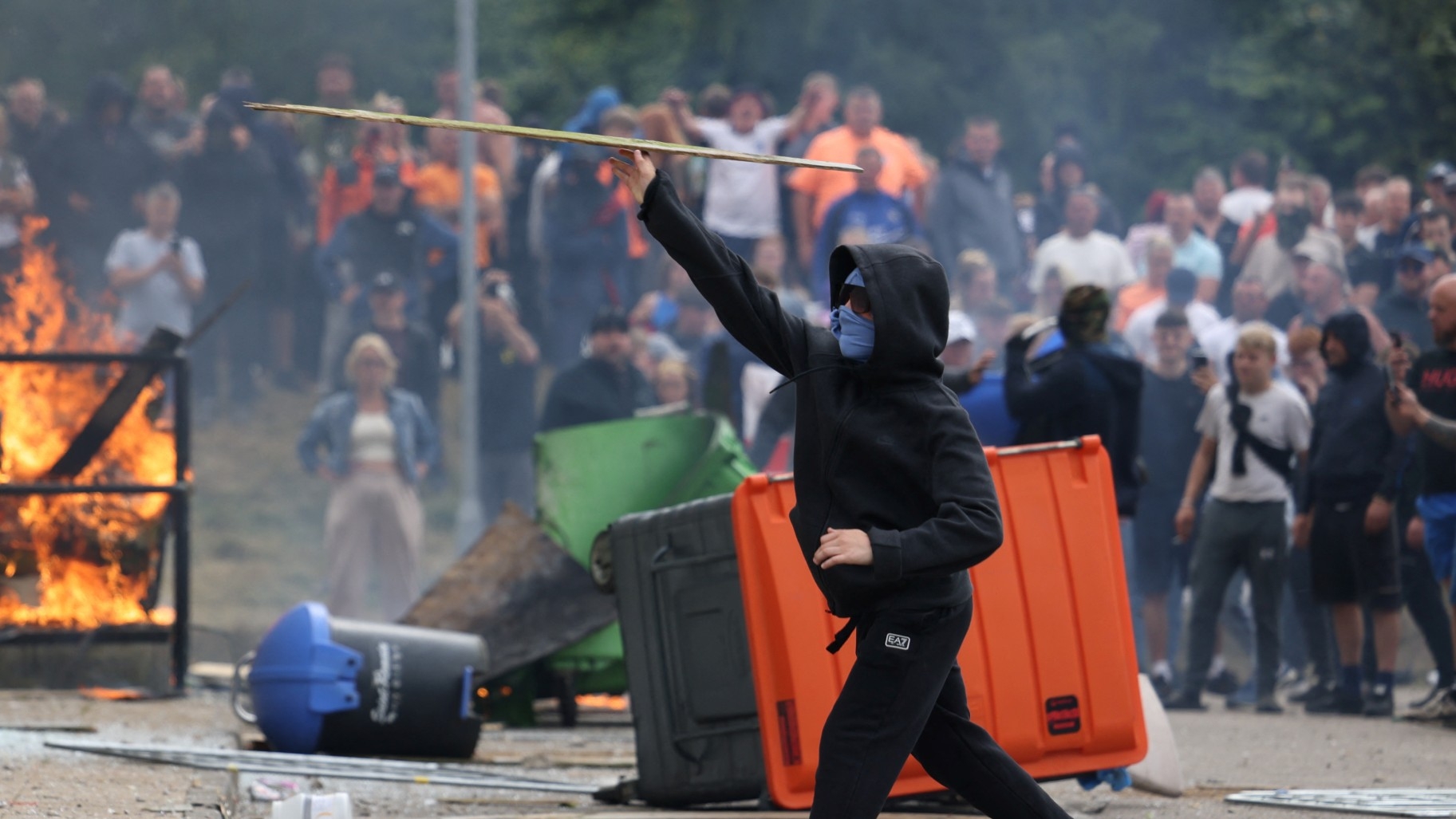 Flames burn as demonstrators take part in an anti-immigration protest, in Rotherham, Britain, 4 August 2024 (Hollie Adams/Reuters)