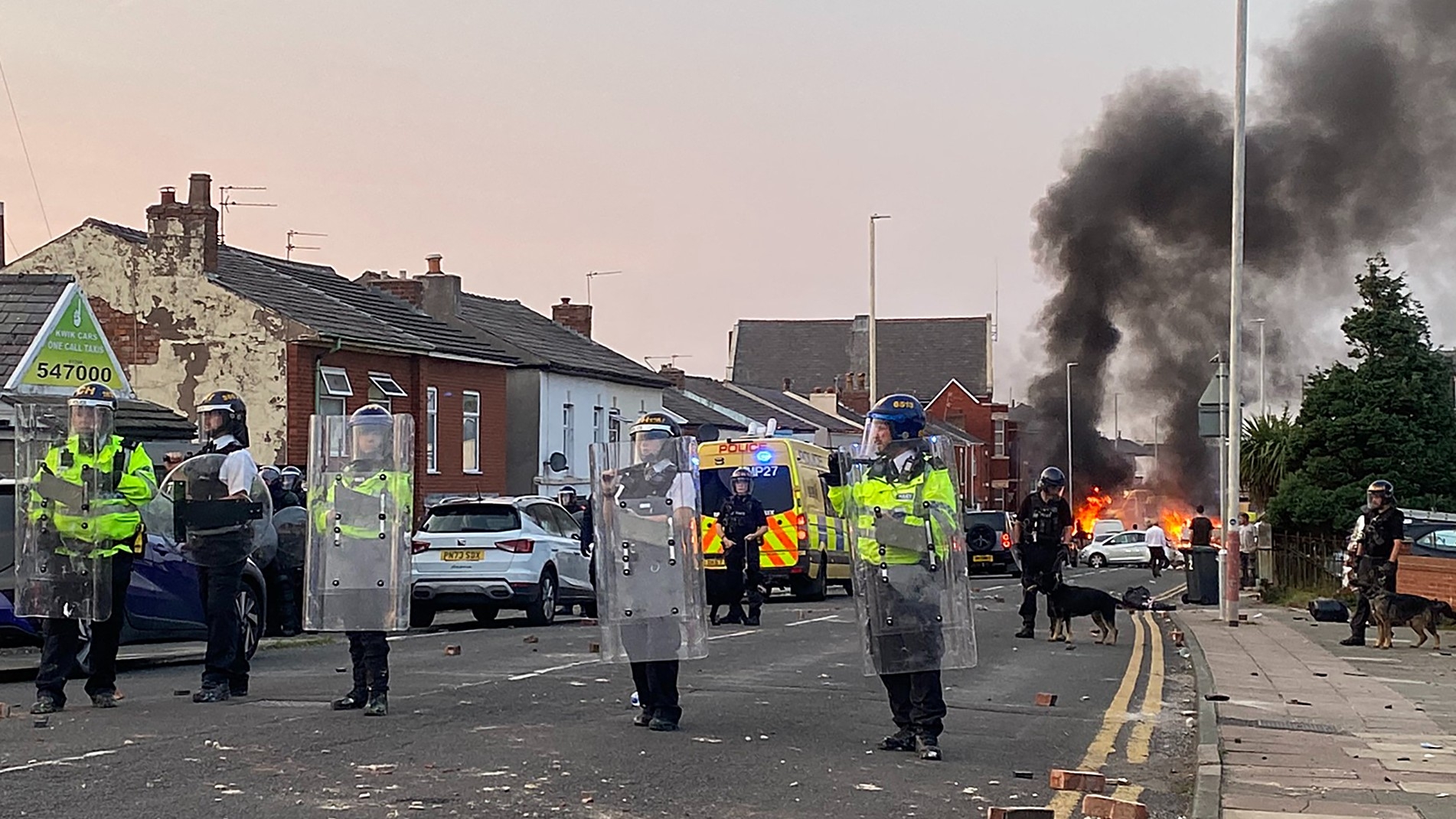 A police van is set on fire as people chanting anti-Muslim slogans clash with police on 30 July, 2024 (Roland Lloyd Parry/AFP)