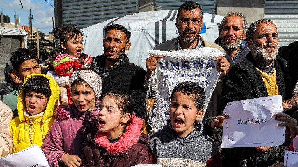 Palestinian men and children gather for a demonstration in Rafah in the southern Gaza Strip on 30 January 2024, calling for continued international support to the United Nations Relief and Works Agency for Palestine Refugees in the Near East (AFP)