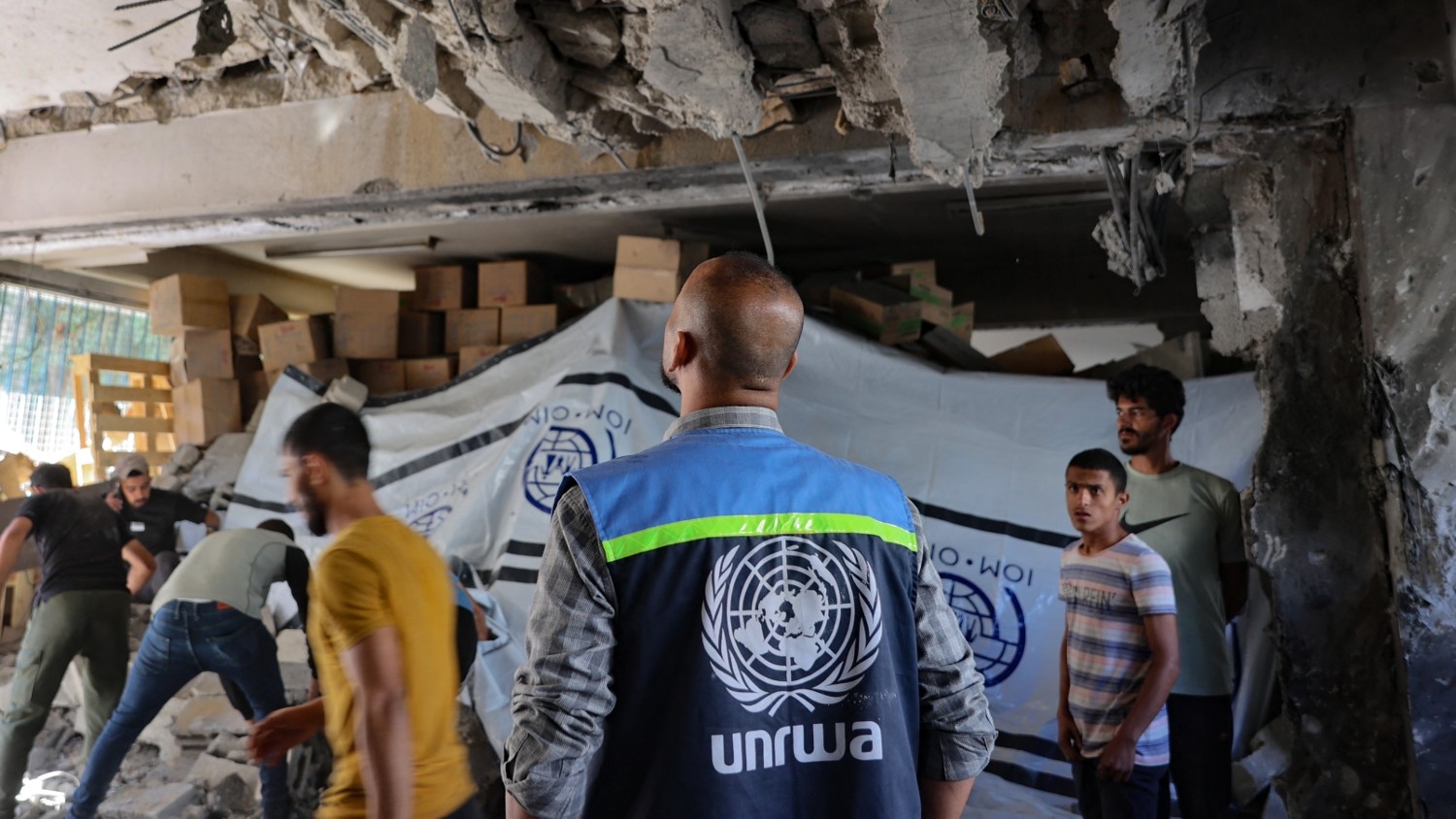 An Unrwa worker and displaced Palestinians check the damage inside a UN school-turned-refuge in al-Shati refugee camp near Gaza City in the northern Gaza Strip, following a reported Israeli strike on October 19 2024.