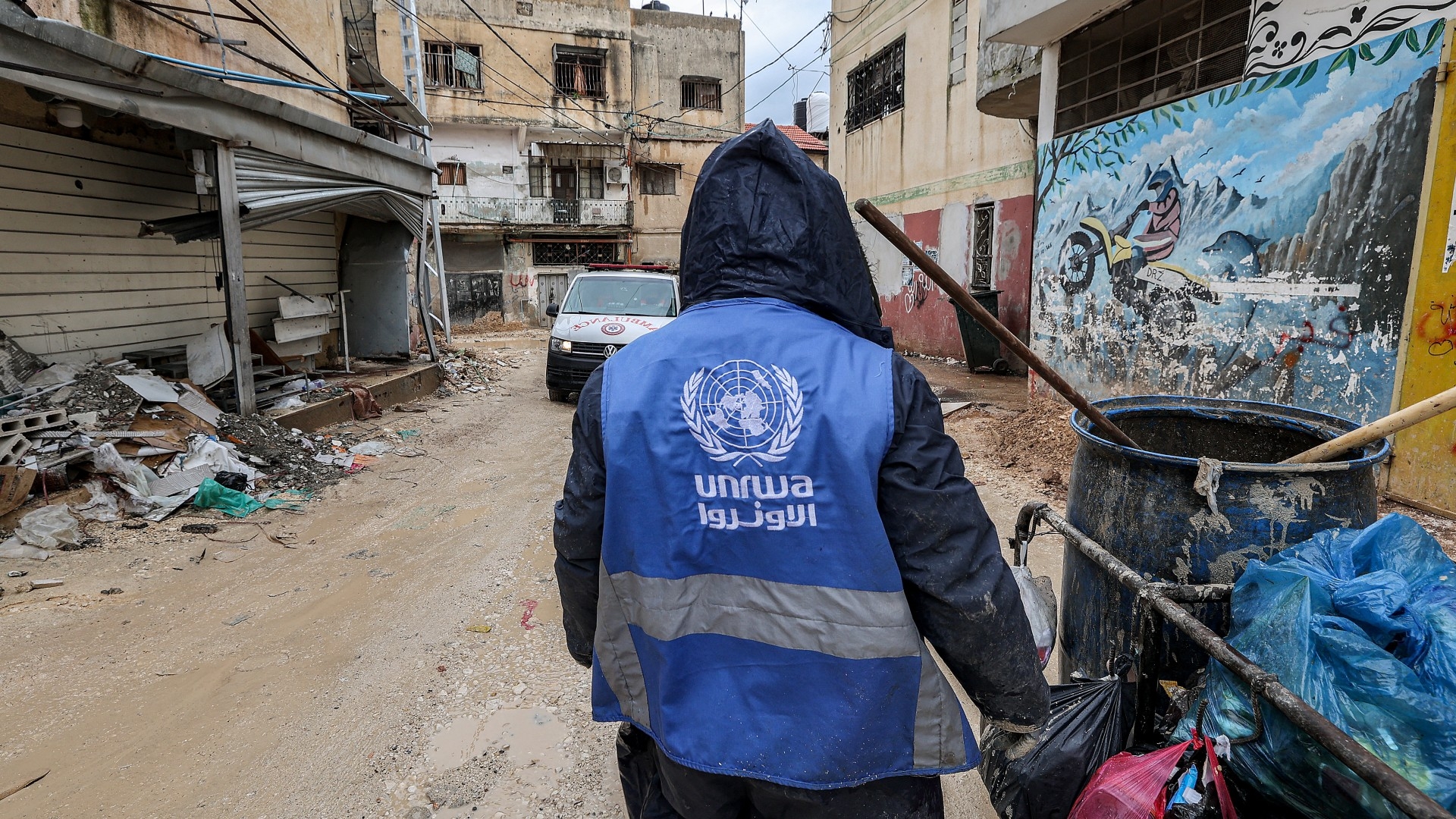 A man wearing a jacket bearing the logo of the United Nations Relief and Works Agency for Palestine Refugees in the Near East (Unrwa), in the city of Jenin in the occupied West Bank on 30 January 2024 (AFP/Jaafar Ashtiyeh)
