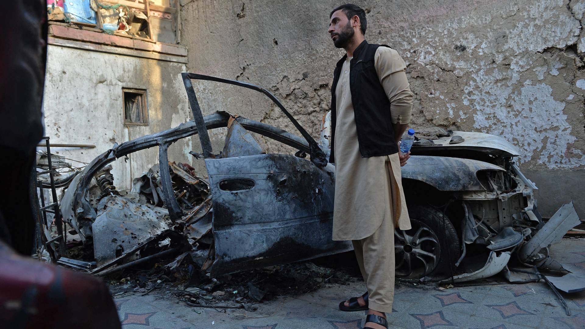 Aimal, brother of Zemari Ahmadi, stands next to the wreckage of a vehicle hit by a US drone strike in the Kwaja Burga neighbourhood of Kabul on 18 September 2021.