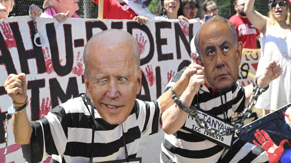 Activists wear masks depicting US President Joe Biden and Israeli Prime Minister Benjamin Netanyahu in Washington on 8 June 8 2024 (Mattie Neretin/Getty Images/AFP)