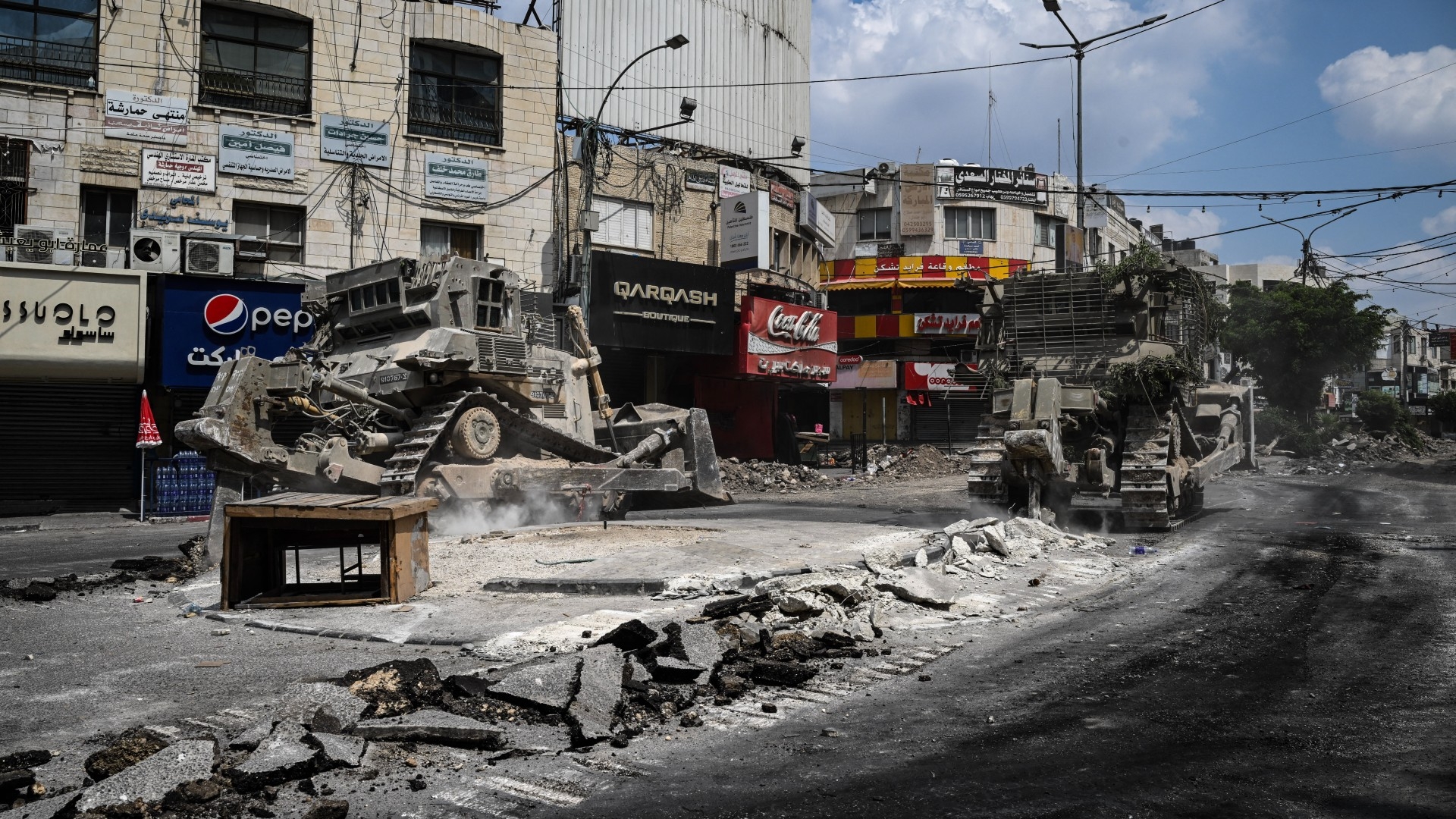 Bulldozers tear up a street during an Israeli raid in the centre of Jenin in the occupied West Bank on 2 September 2024 (AFP/Ronaldo Schemidt)