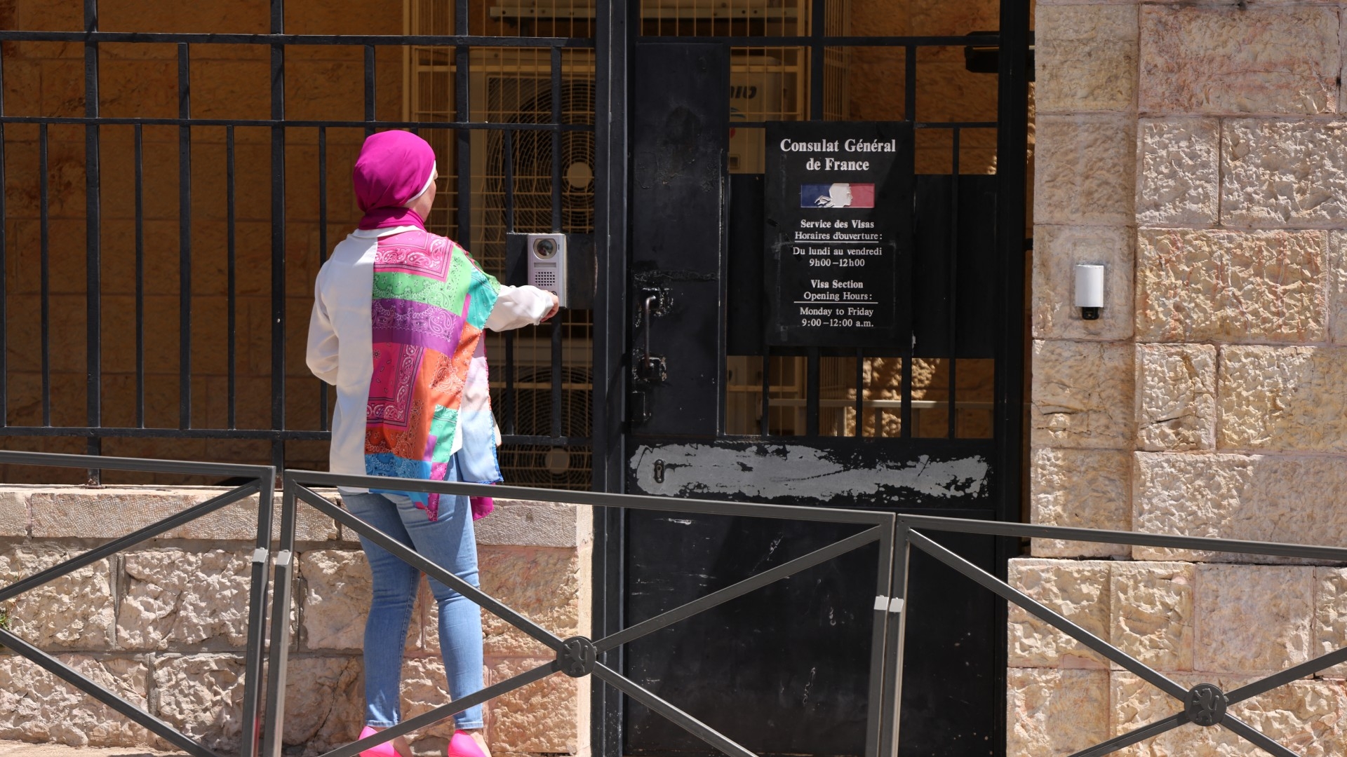 A woman rings the bell of the French consulate in Jerusalem on 18 June 2024 (AFP/Menahem Kahana)