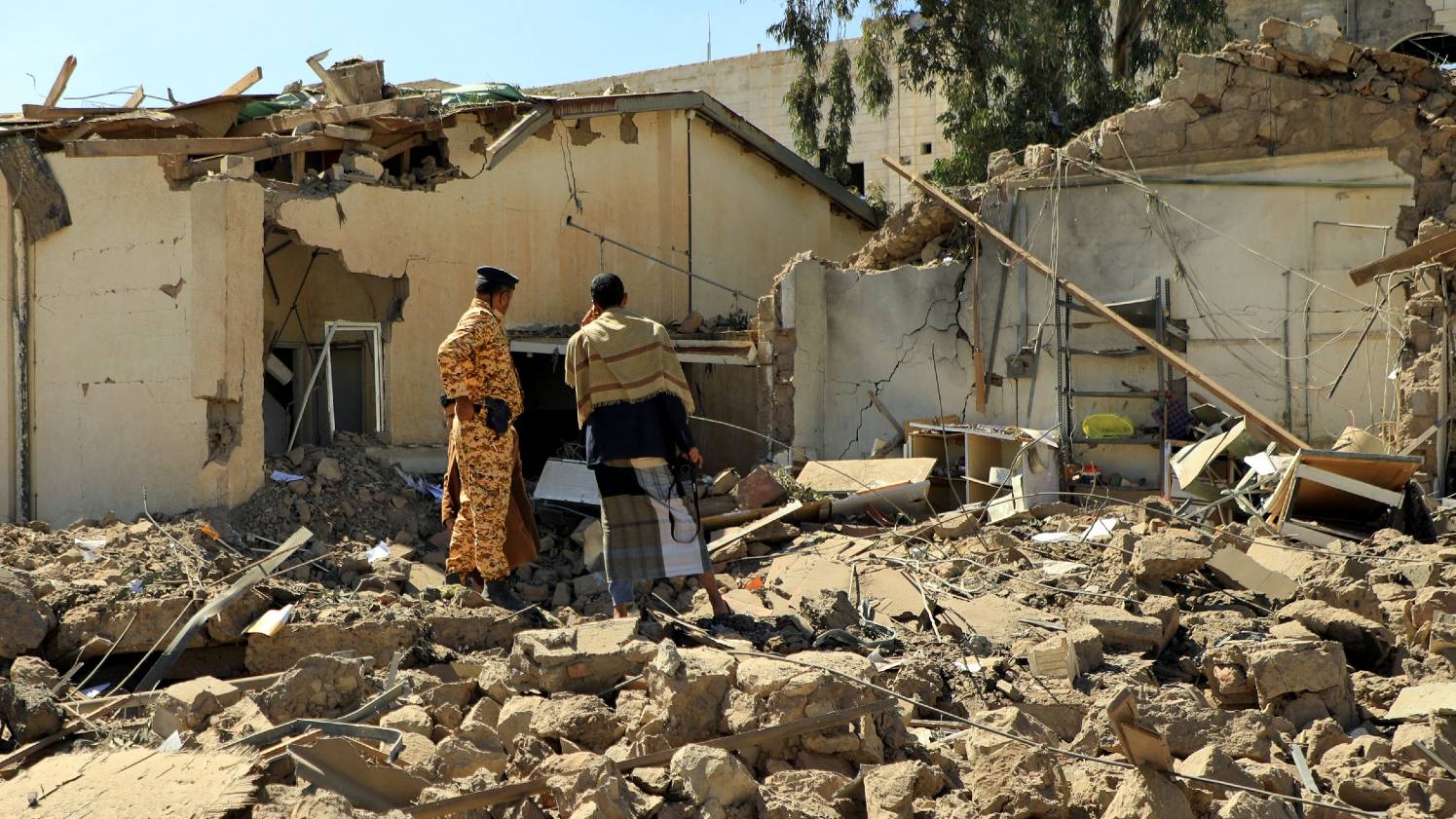 Yemenis inspect the damage in the vicinity of the telecommunication ministry following Saudi-led coalition air strikes targeting the capital of Sanaa, on 14 February 2022.