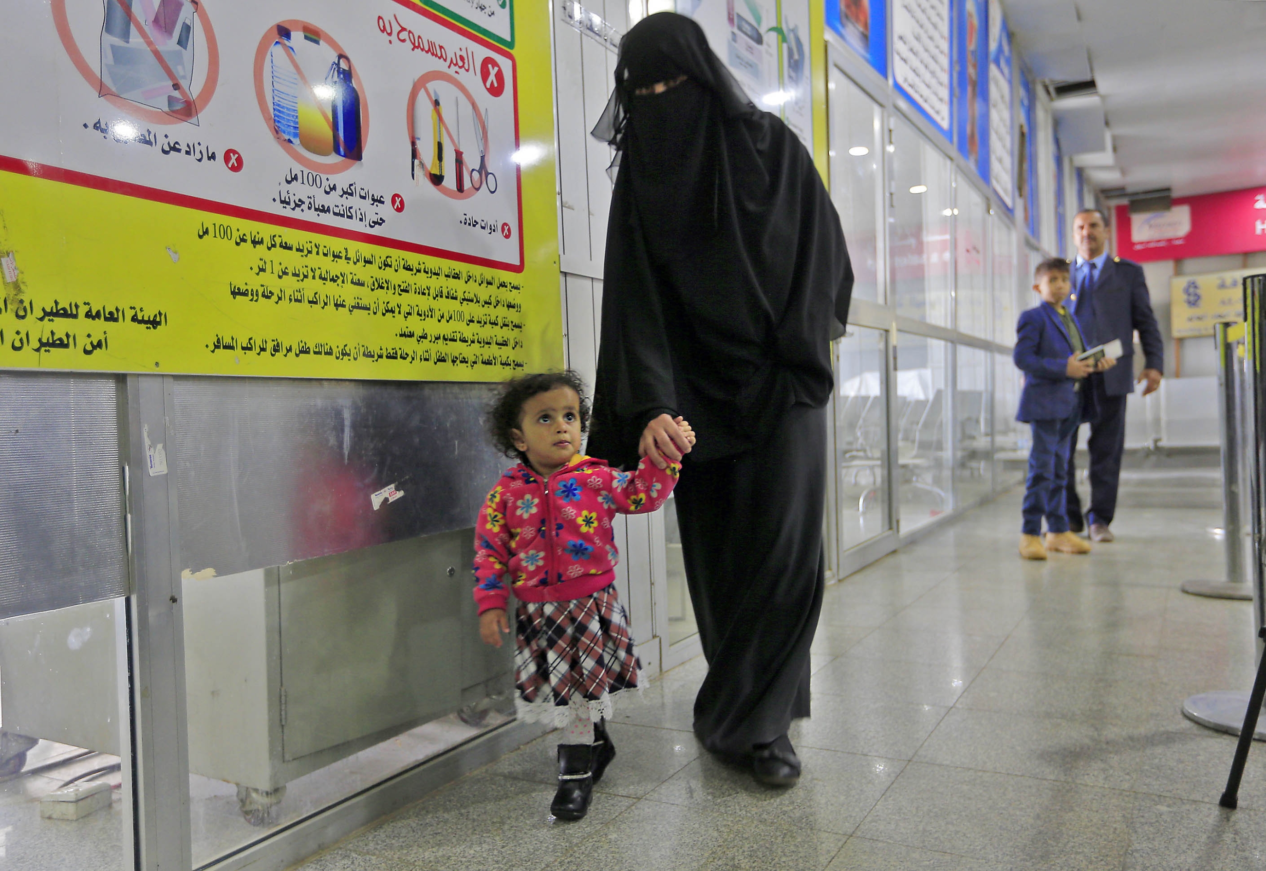 A Yemeni child walks with their guardian at Sanaa International Airport