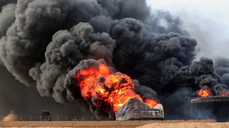 Smoke billows from a raging fire at oil storage tanks a day after Israeli strikes on the port of Yemen's Hodeidah on 21 July 2024 (AFP)