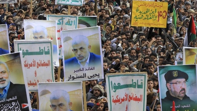 Yemenis lift placards and flags and hold portraits of newly appointed Hamas leader Yahya Sinwar, and slain leaders, Hezbollah senior commander Fuad Shukr and Ismail Haniyeh of the Palestinian group Hamas, during a rally in the Houthi-controlled capital Sanaa in solidarity with Palestinians on 16 August 2024 (AFP)