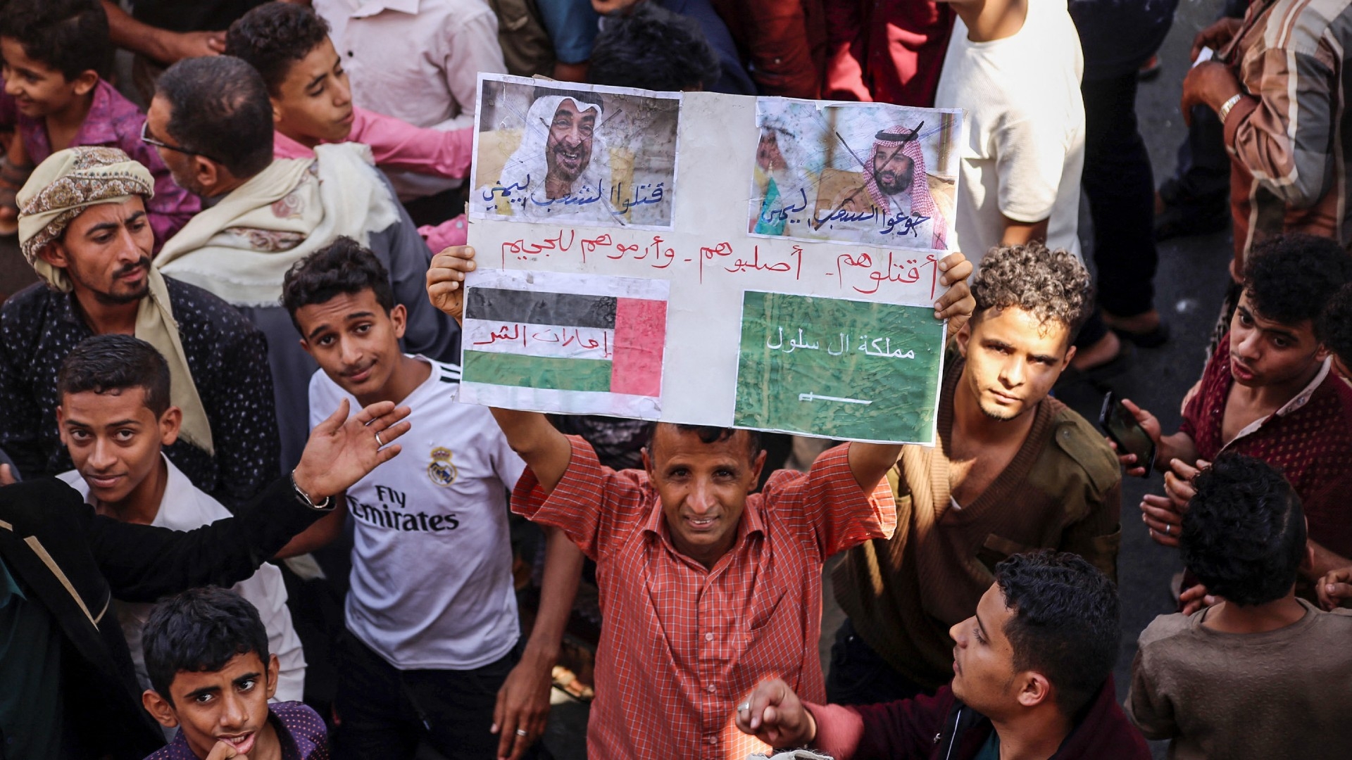 Un manifestant yéménite brandit une pancarte comportant les visages barrés du prince héritier saoudien Mohammed ben Salmane (à droite) et du président émirati Mohammed ben Zayed (à gauche) dans la ville yéménite de Ta’izz, le 4 octobre 2018 (AFP/Ahmad al-Basha)