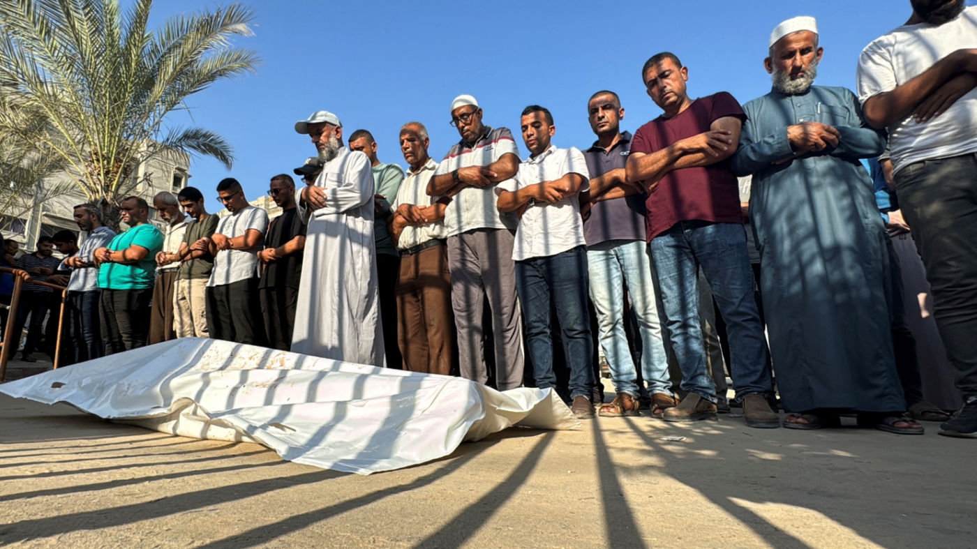 Mourners pray next to the body of a Palestinian killed in the Israeli attack on al-Mawasi on 10 September 2024 (Mohammed Salem/Reuters)