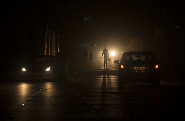 Palestinians walk on a street at the Al-Shati refugee camp in Gaza City during a power outage on 11 June (AFP)