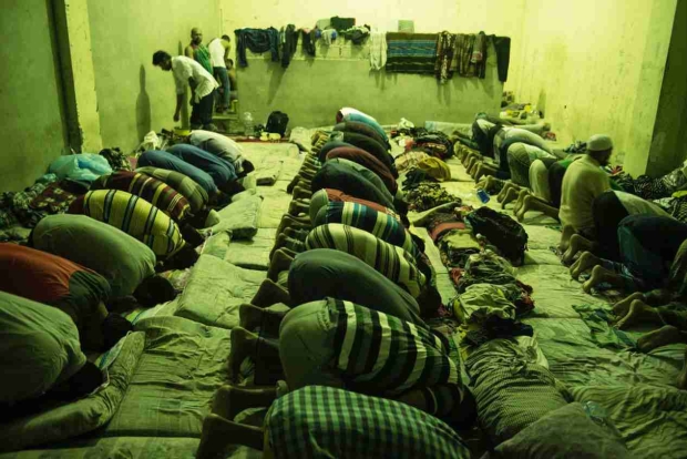 Men pray amid cramped conditions at the al Nasr centre in Zawhia (Alessio Romenzi/MEE)