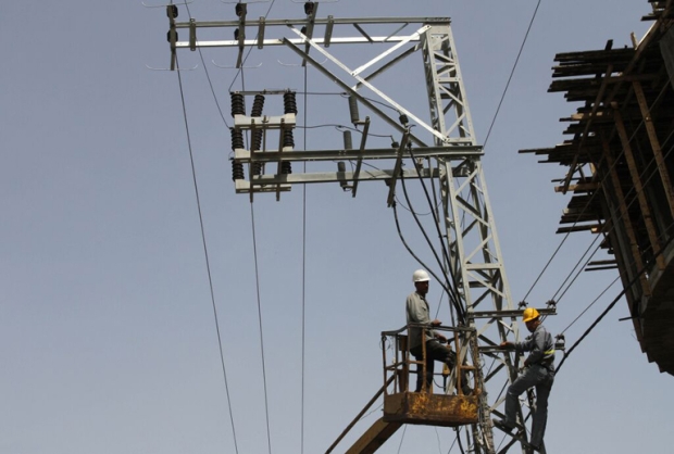 A couple of Gazan electricity company employees work to repair power lines (MEE/Mohammed Asad)