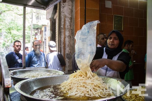 Umm Amira, 42, worked at a small cart selling fried potatoes for seven years then bought her own shop in downtown Cairo (MEE/Belal Darder)