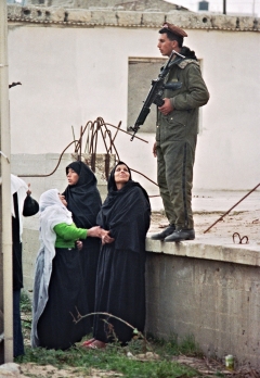 Palestinian women argue with an Israeli soldier (r) as they line up outside Ansar II prison camp in Gaza in February 1988, to visit their sons, held prisoners (AFP)