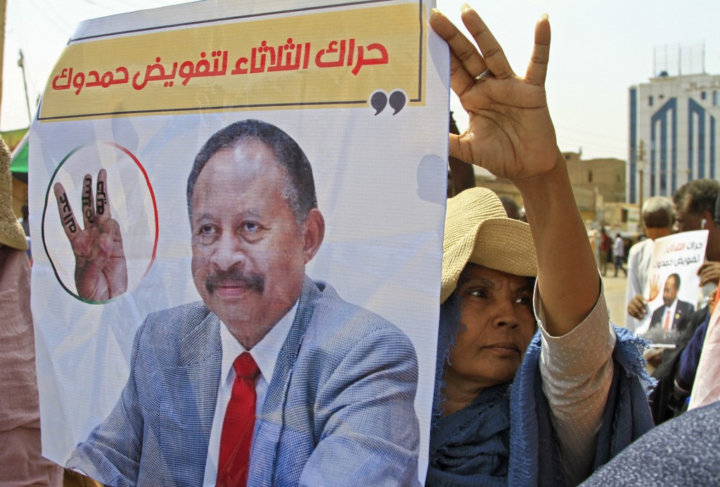 Sudanese protesters lift placards supporting the reinstatement of Abdalla Hamdok, the Prime Minister ousted in the October military coup, during an anti-coup demonstration in the Bashdar station area in southern Khartoum, on July 26, 2022