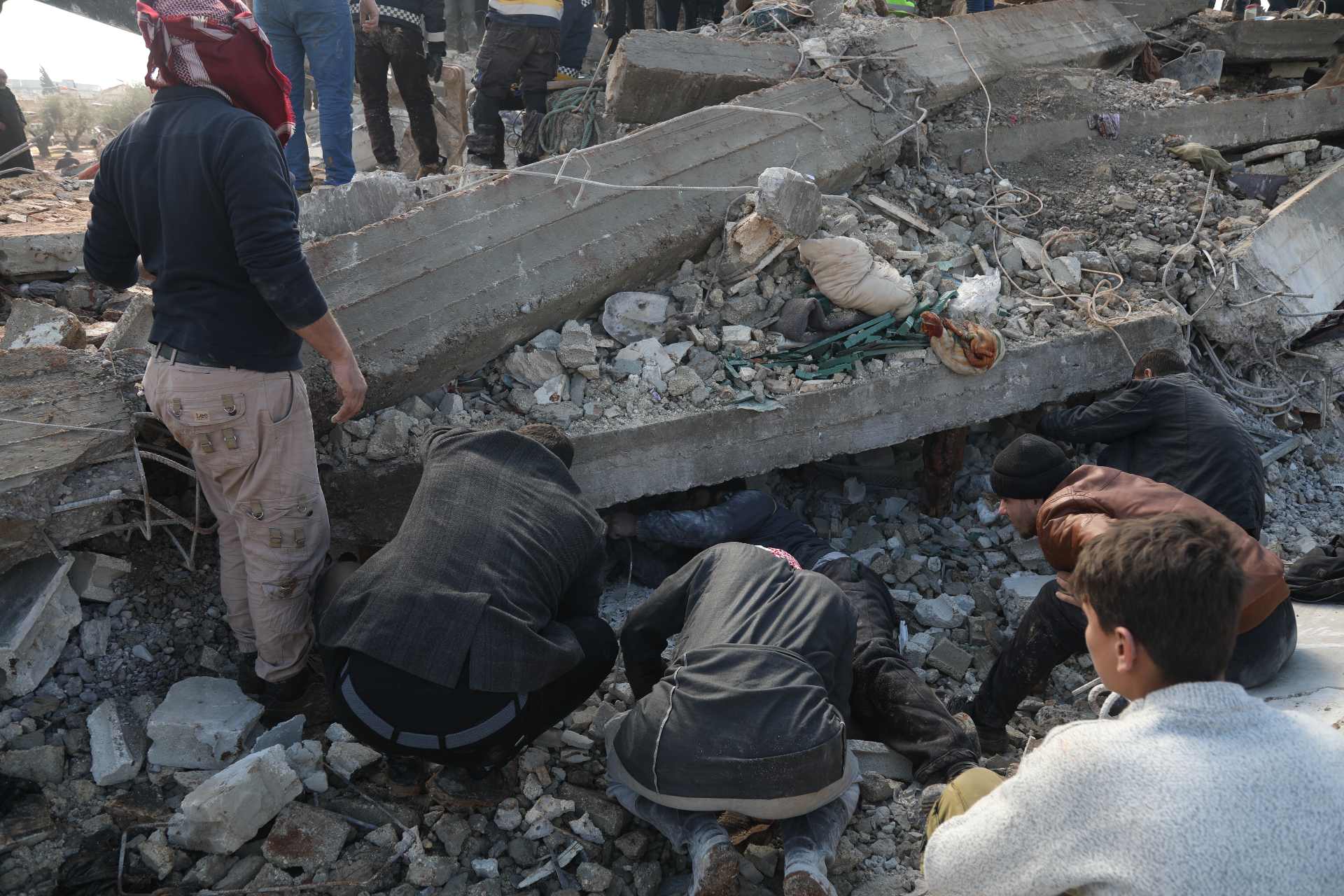 Des personnes fouillent des décombres à Jandairis, à l’ouest d’Alep, le 7 février (MEE/Ali Haj Suleiman)