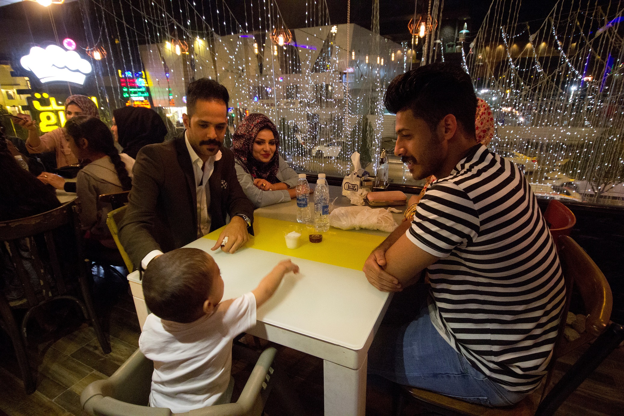 A family enjoying a meal at a Syrian restaurant in Mansour, Baghdad (MEE/Charlotte Mayhew)