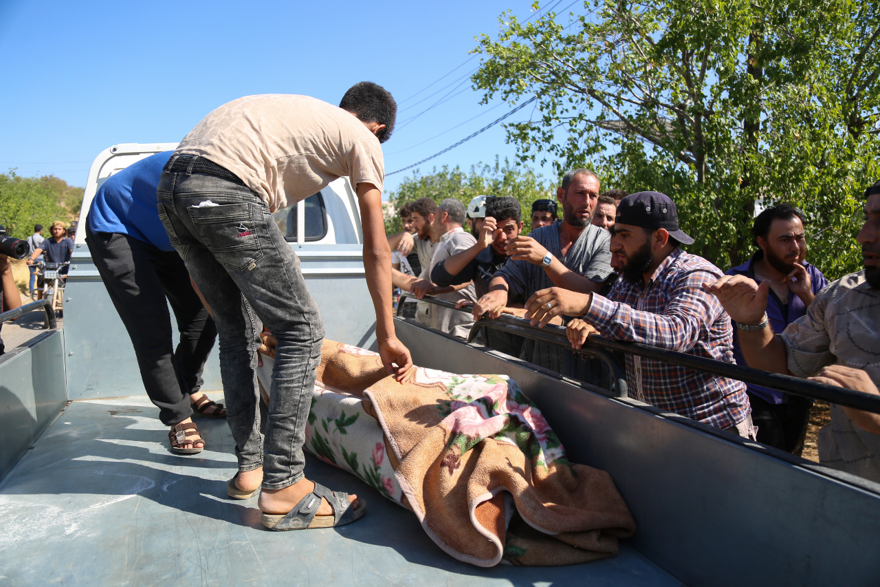 The body of one of the civilians killed in the shelling is placed in a truck (MEE/Ali Haj Suleiman)