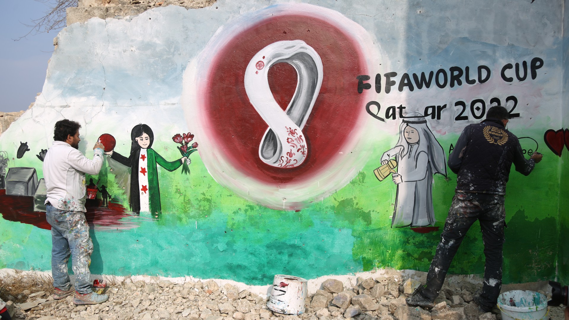 Syrian painter Aziz al-Asmar paints a mural in Idlib in support of the Qatar World Cup (MEE/Ali Haj Suleiman)