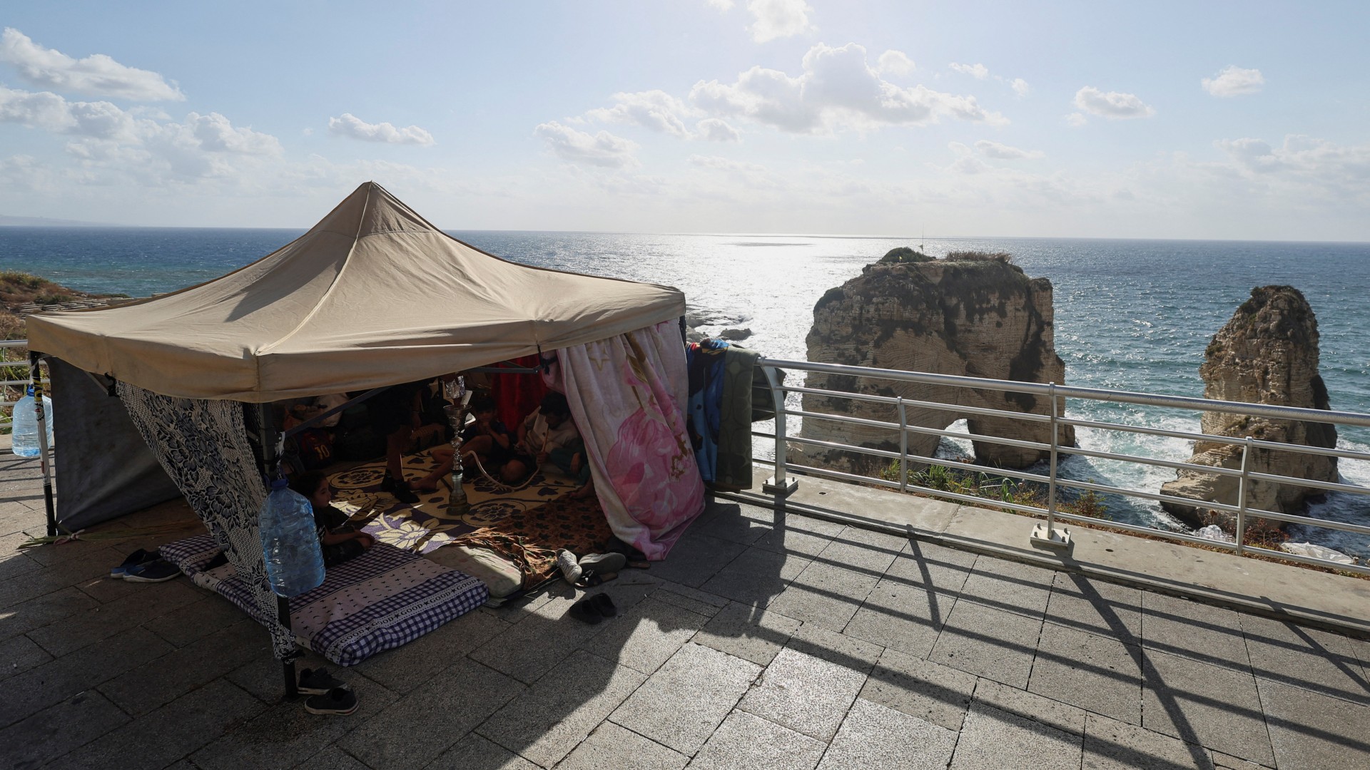 A displaced Syrian family sits in a makeshift tent as they seek refuge along the city's corniche after their family home in Beirut's southern suburb of Dahiyeh was damaged by an Israeli airstrike, amid the ongoing hostilities between Hezbollah and Israeli forces, in Beirut, Lebanon October 1, 2024. REUTERS/Amr Abdallah Dalsh