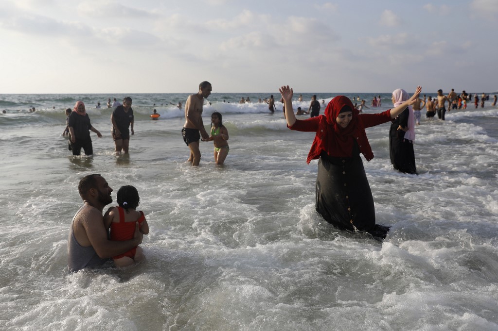Palestinians enjoy the Mediterranean sea on a beach in Tel Aviv during the Eid al-Adha holiday on August 22, 2018. Thousands of Palestinians from the West Bank visited beaches in and around the Israeli commercial capital Tel Aviv during the Eid al-Adha holiday.