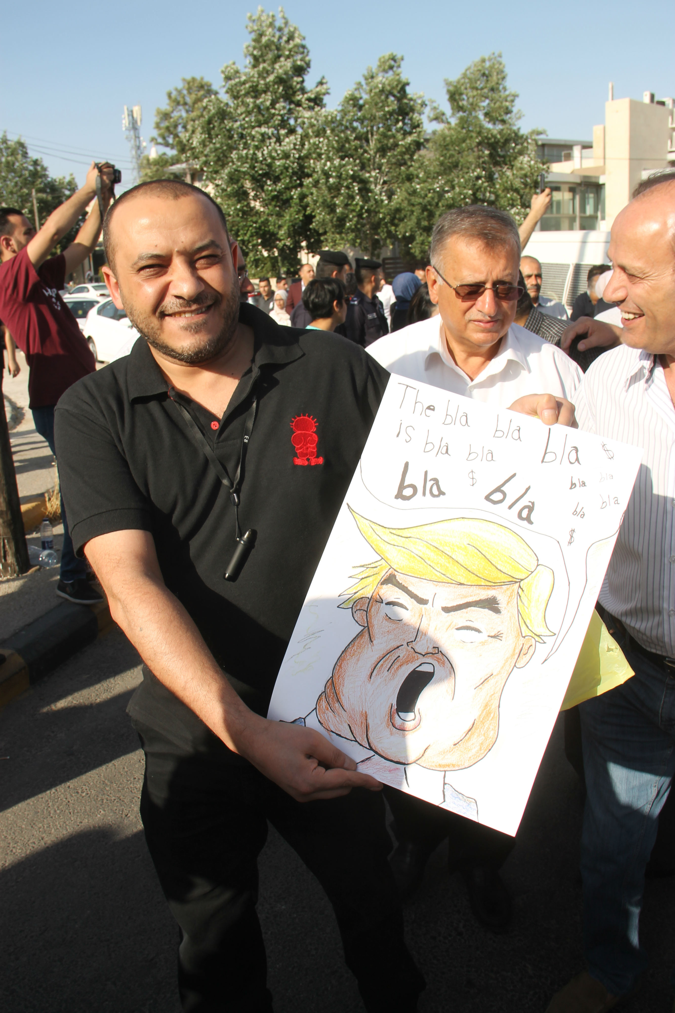 A protester holds an image of Donald Trump at a rally against his "deal of the century" in Amman (MEE/Mohammed Ersan)