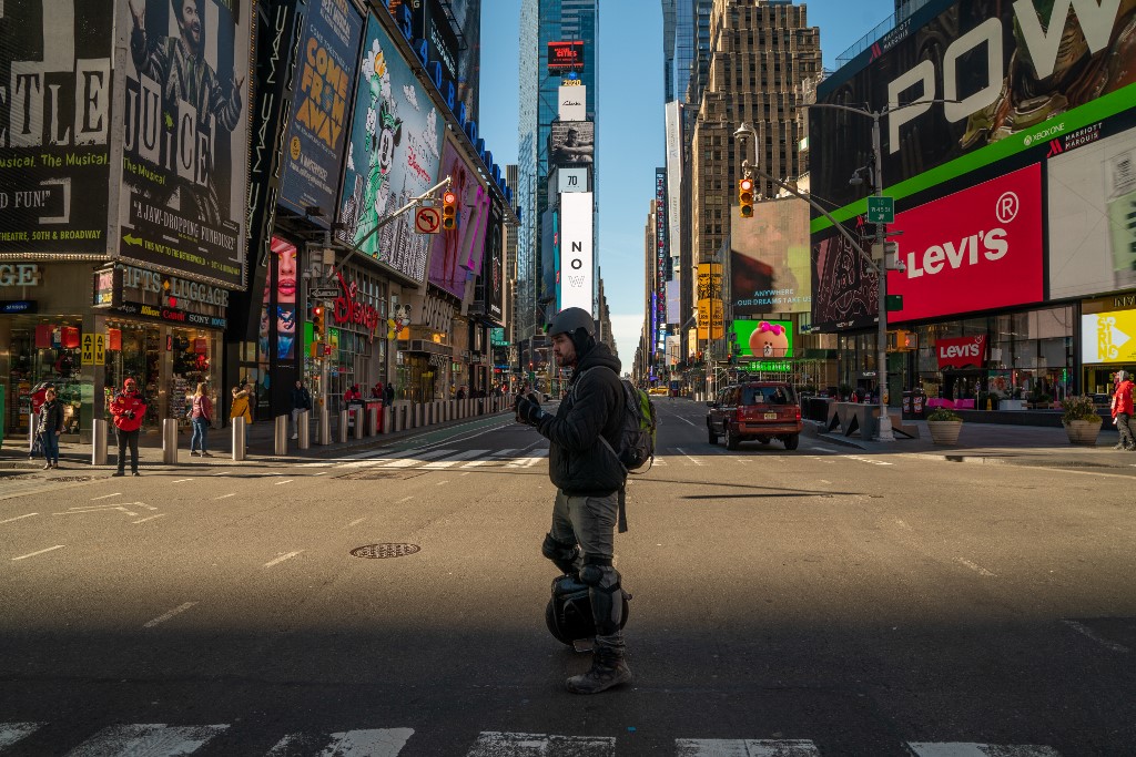 A person walks through a nearly empty Times Square in New York City on 12 March (AFP)