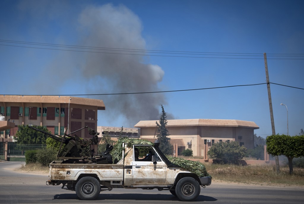 Smoke rises above buildings south of Libya’s Tripoli on 29 April (AFP)