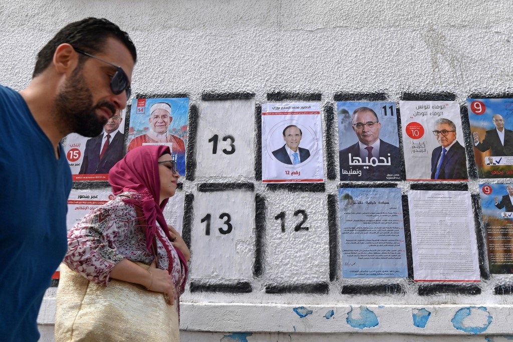 Posters of some of the 26 presidential candidates posted in Tunis (AFP) 