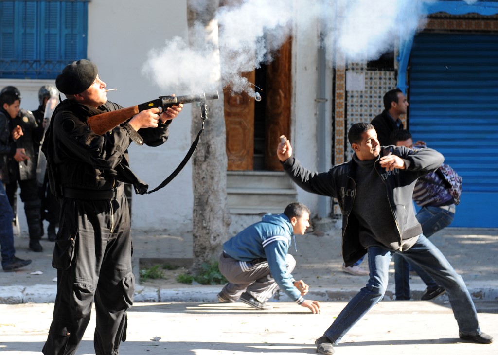 La police gaze des manifestants rassemblés devant le siège du gouvernement à Tunis le 26 janvier 2011 pour demander l’éviction des personnalités liées au régime déchu de Ben Ali (AFP)