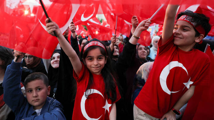 Supporters of Turkish President Recep Tayyip Erdogan react after early exit polls at the AK Party HQ in Ankara on 14 May (Reuters)