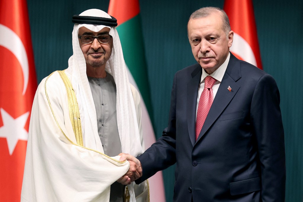 Turkish President Recep Tayyip Erdogan shakes hands with Abu Dhabi Crown Prince Mohammed bin Zayed in Ankara on 24 November 2021 (AFP)