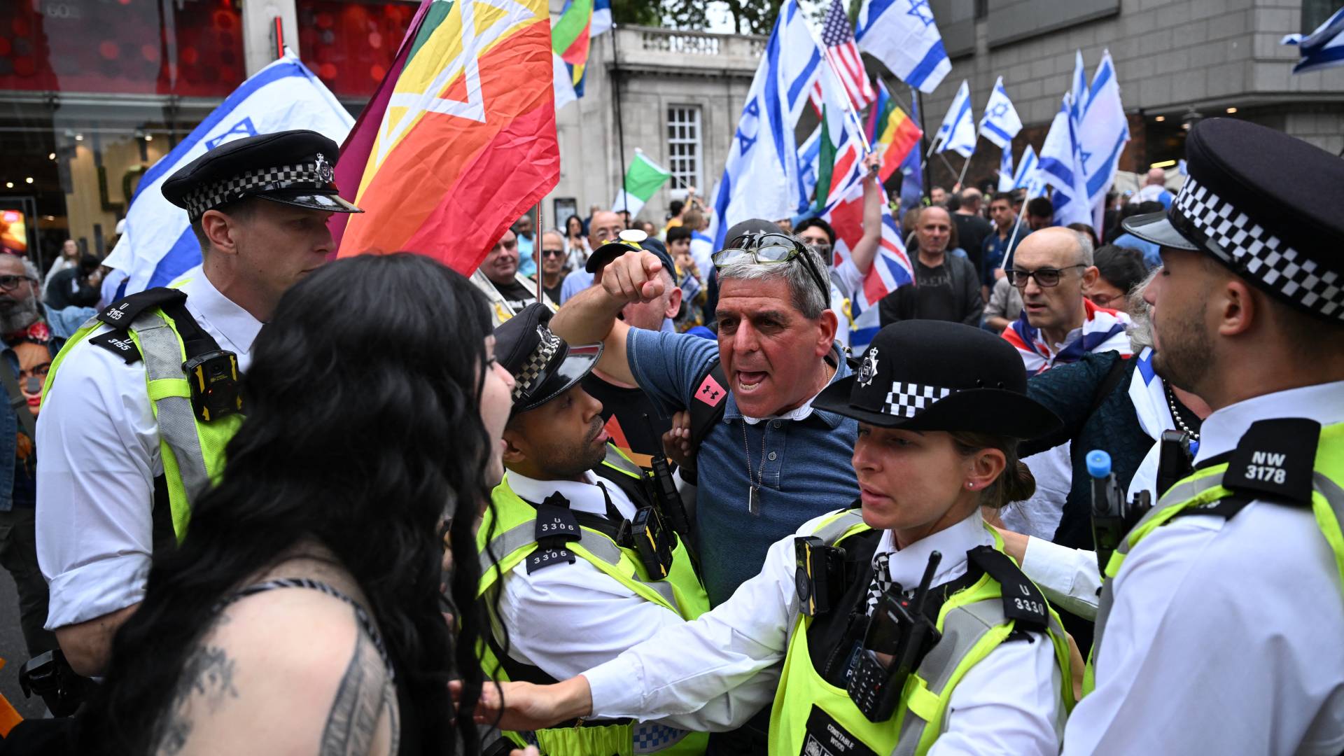 Participants in pro-Palestine and pro-Israel demonstrations face each other, separated by police, outside the Israeli embassy on 7 September 2024 (Justin Tallis/AFP)