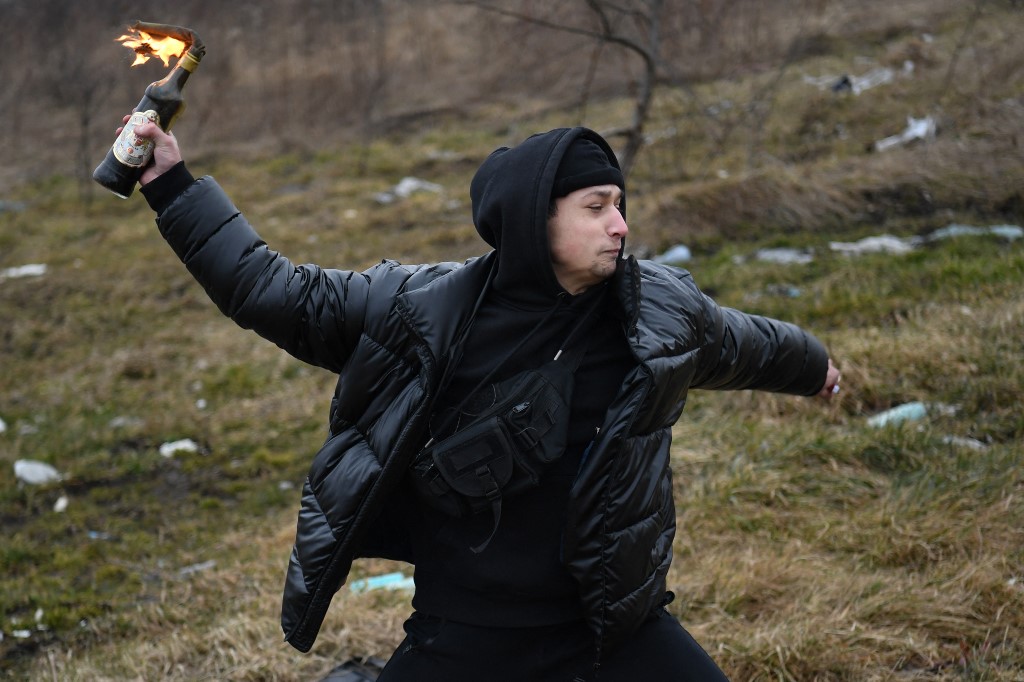 A young man throws a Molotov cocktail during a civilian self-defence course on the outskirts of Lviv, western Ukraine, on 4 March 2022 (AFP)