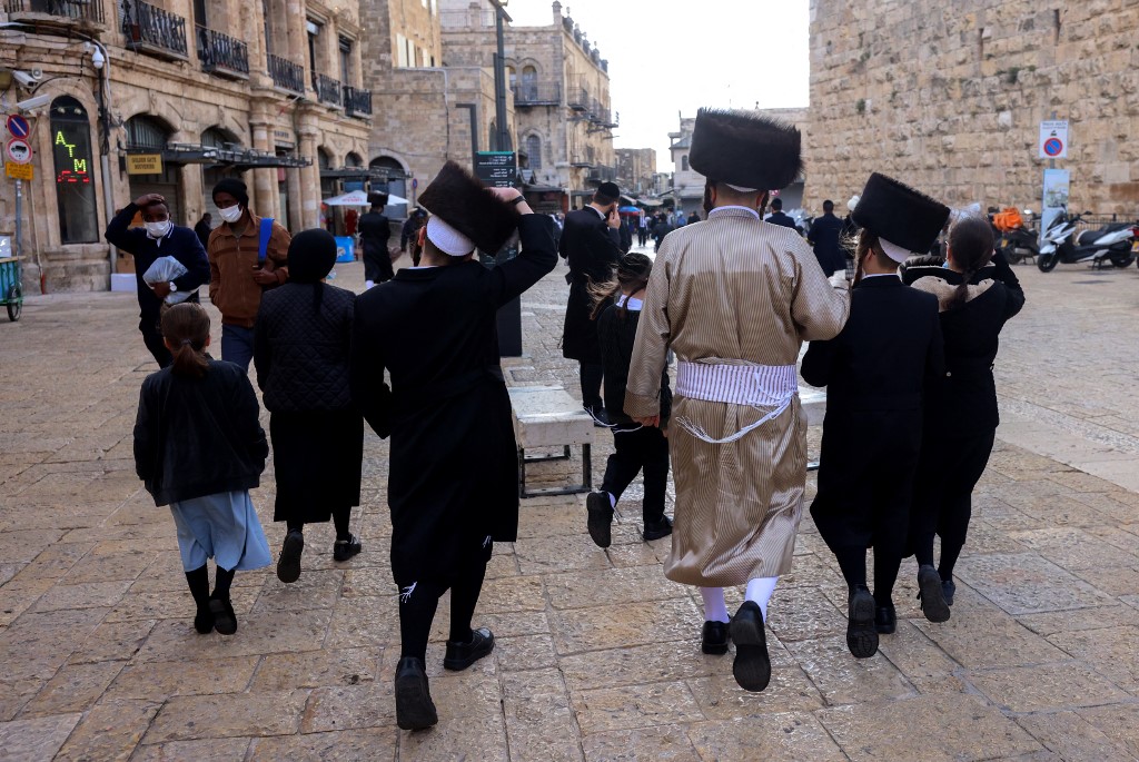 An ultra-Orthodox Jewish family walks in Jerusalem’s Old City on 2 April 2021 (AFP)