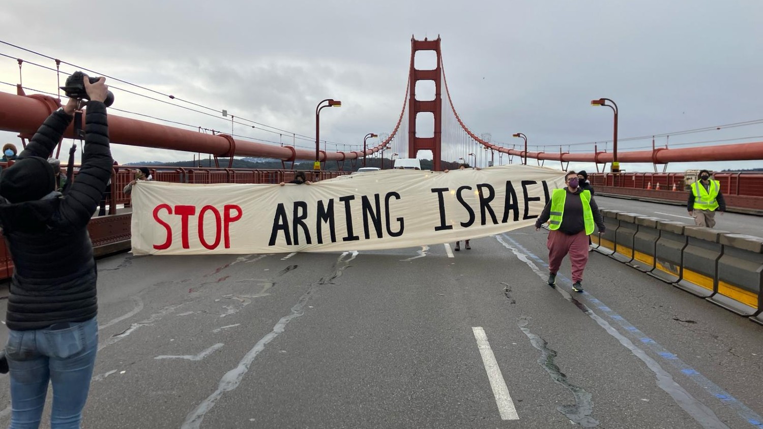 Pro-Palestine protesters disrupt traffic on the Golden Gate Bridge in California, holding a banner saying "Stop Arming Israel" on 14 February 2024.