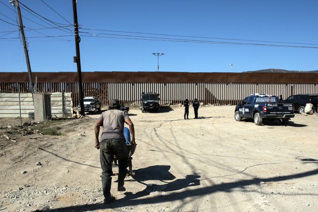 Mexican security forces guard the US-Mexico border fence on 18 September (AFP)