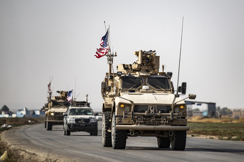 US military vehicles traverse the northern Syrian town of Tal Tamr on 20 October (AFP)