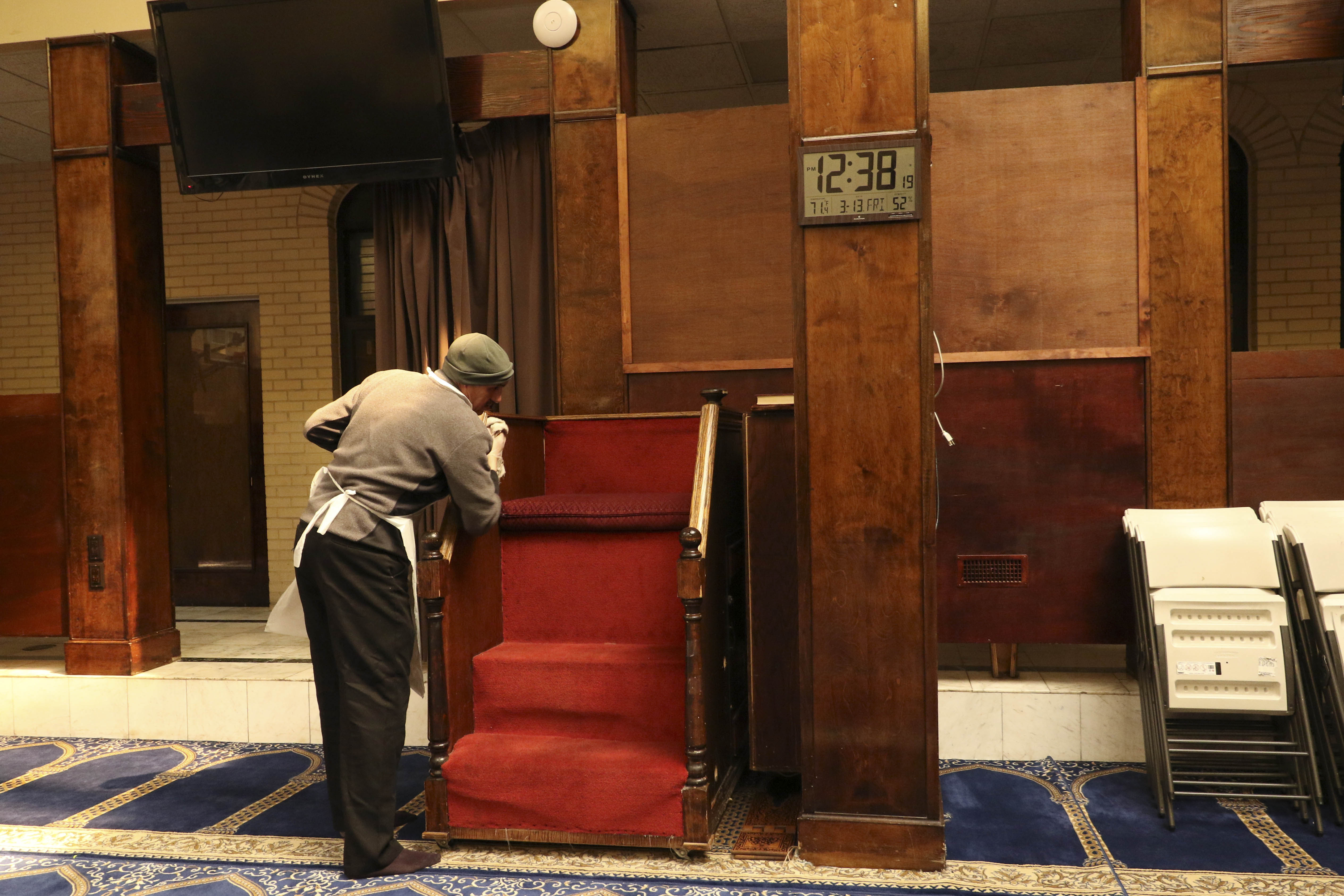 A man is cleaning the inside of the mosque.